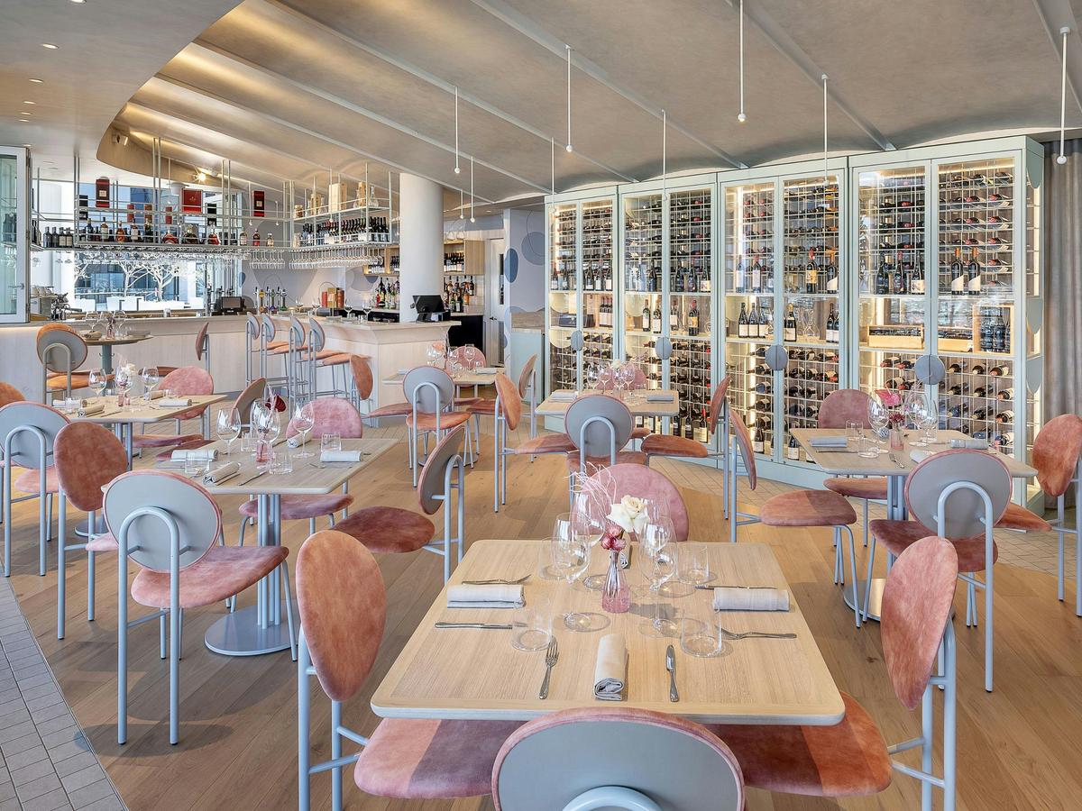Aloria's inside dining room, with pink chairs and a wine cellar wall