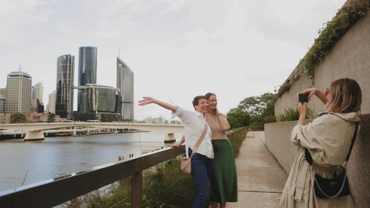 A guide takes photos of guests on the Brisbane River
