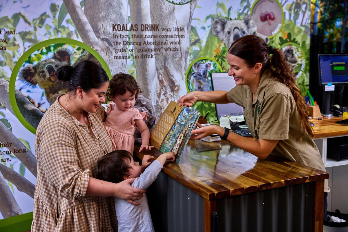 A family receiving a printed photo at Cairns Koalas & Creatures in Cairns City.