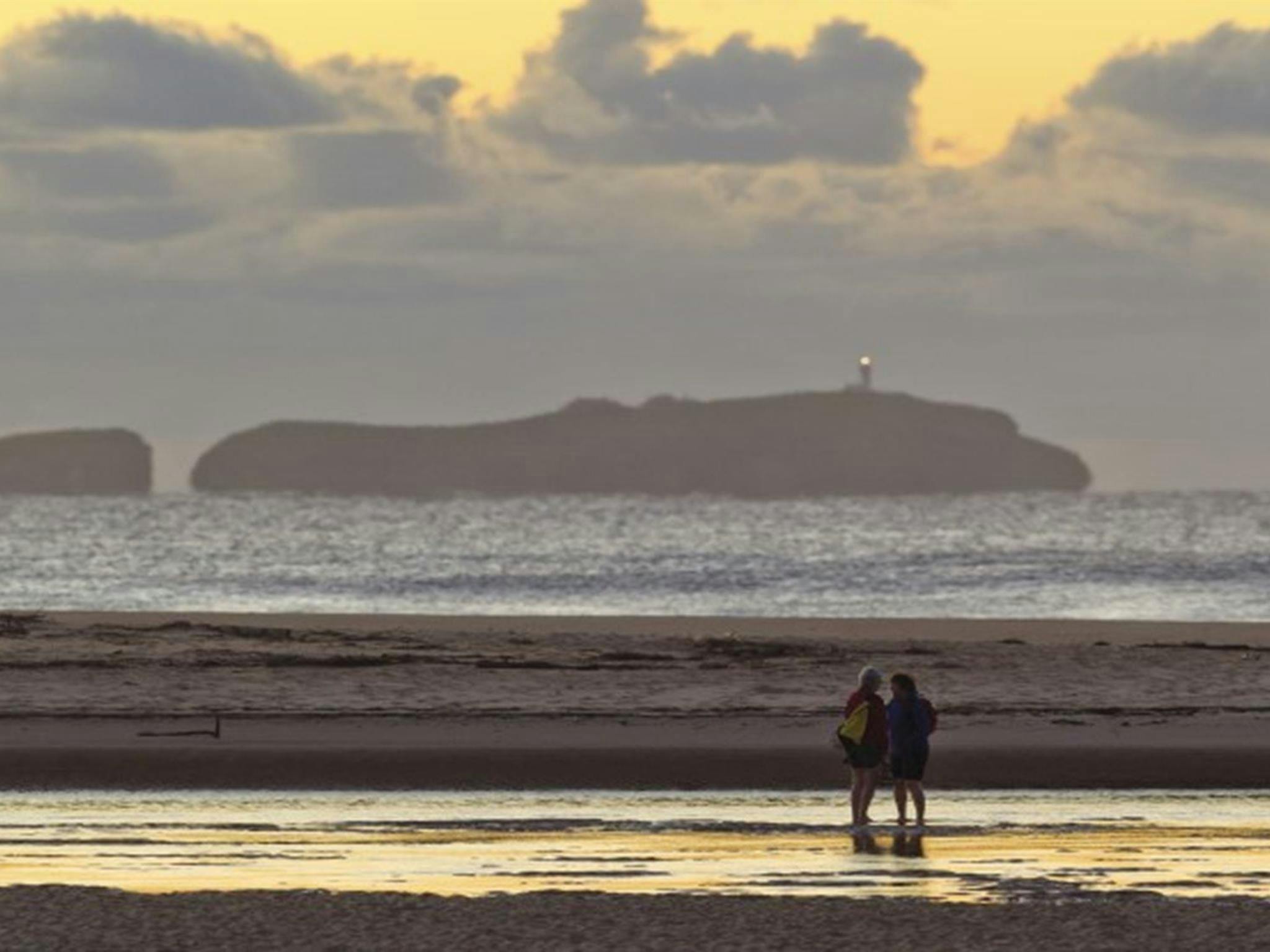 A couple on the shores of Moonee Creek in Moonee Beach Nature Reserve. Photo: Rob Clear &copy; OEH