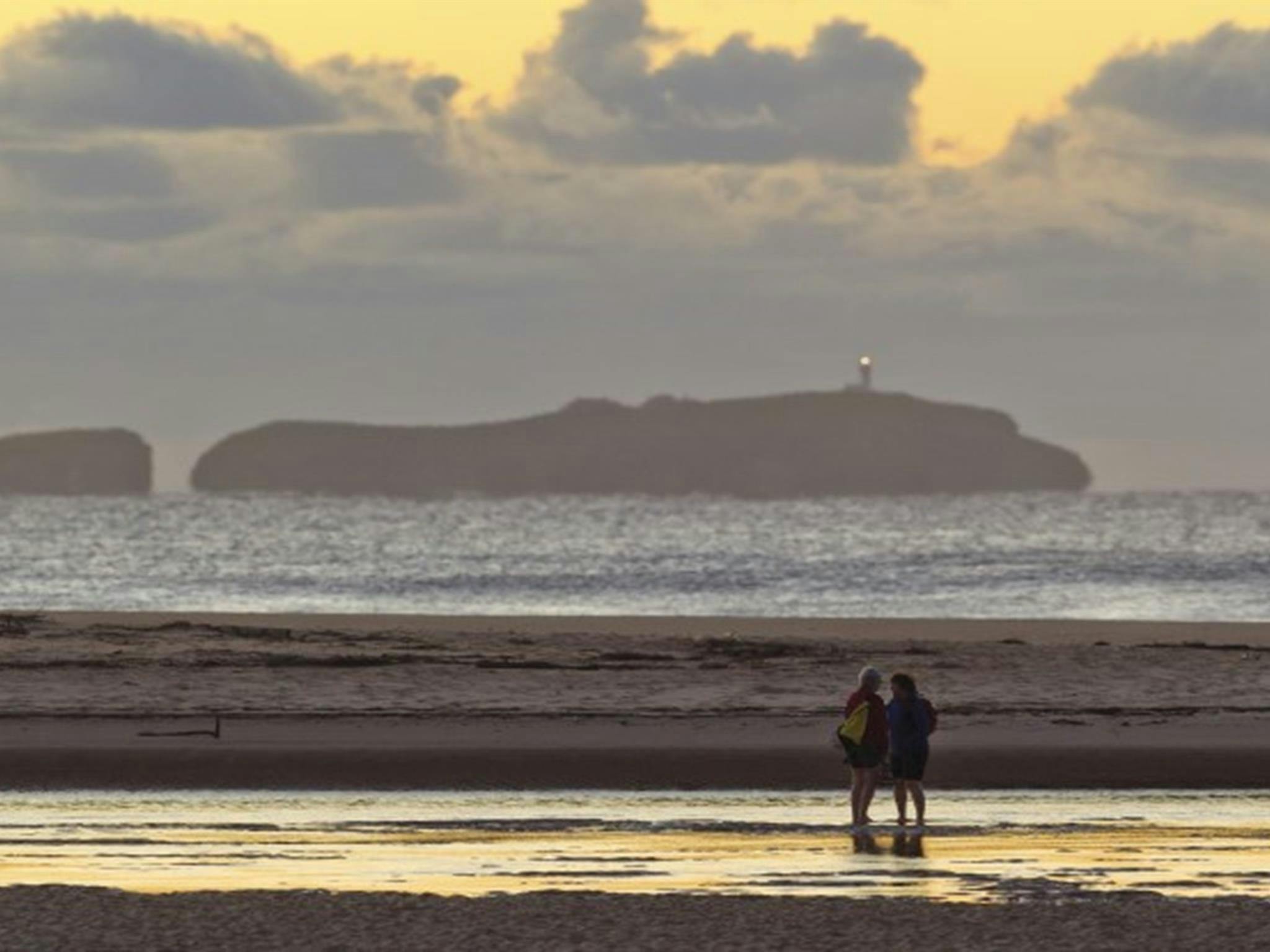 A couple on the shores of Moonee Creek in Moonee Beach Nature Reserve. Photo: Rob Clear &copy; OEH