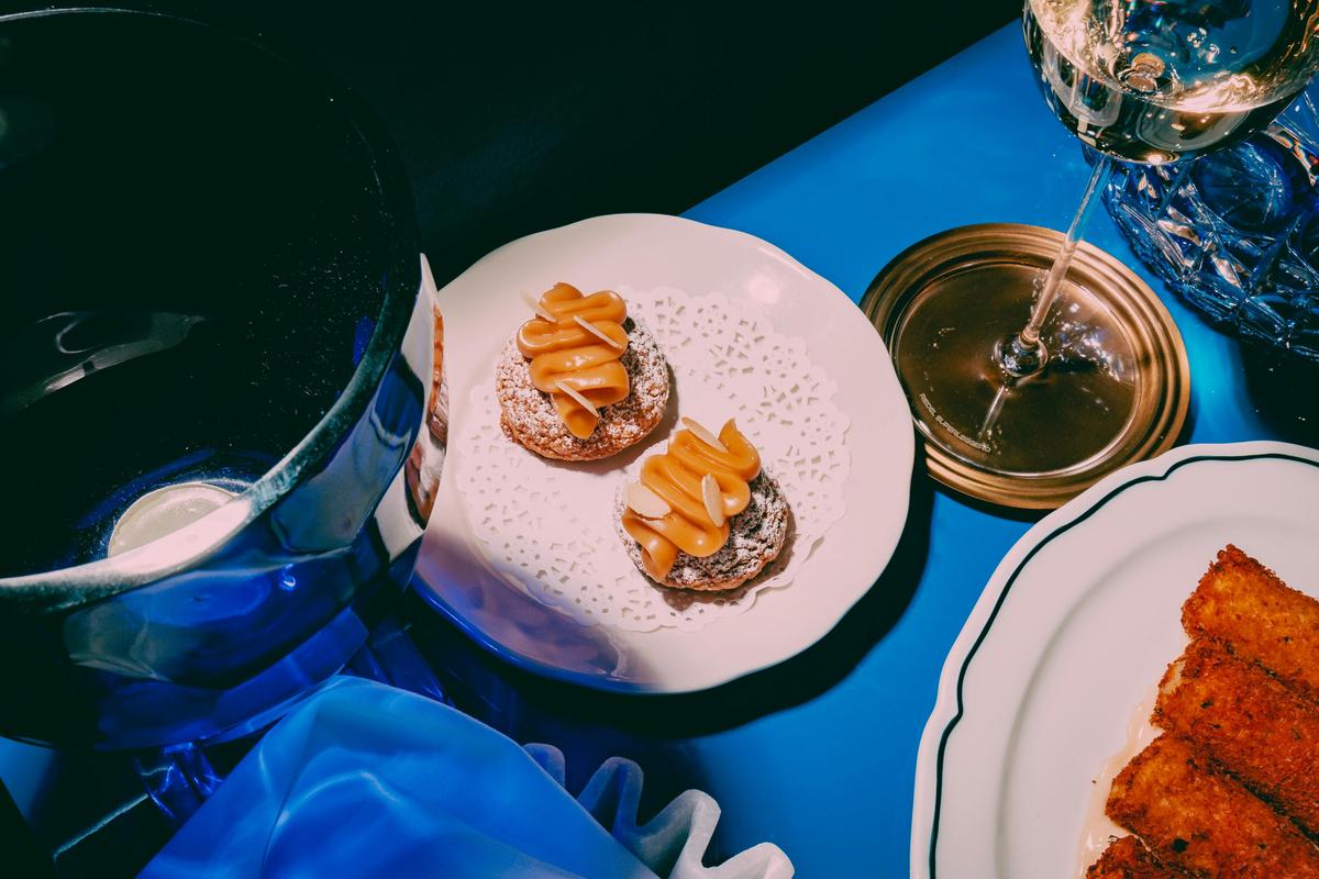 A photo of some beautiful canapes, and on a white plate and blue table