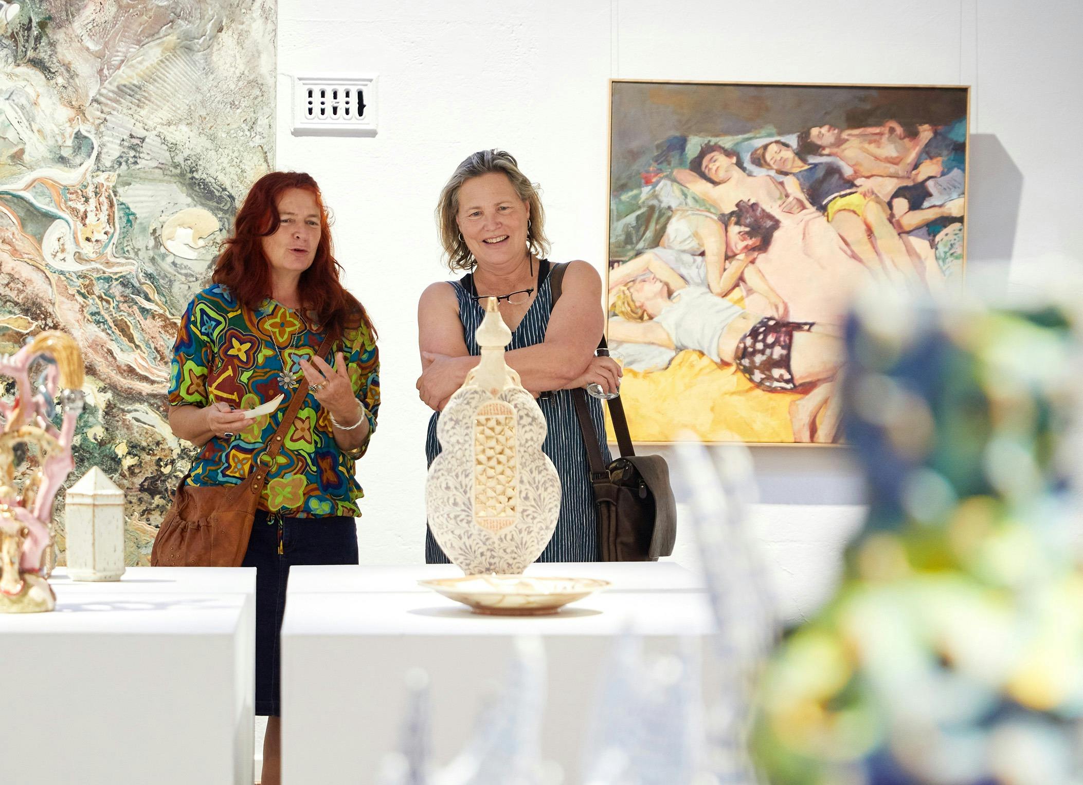 Two people looking at ceramic artworks