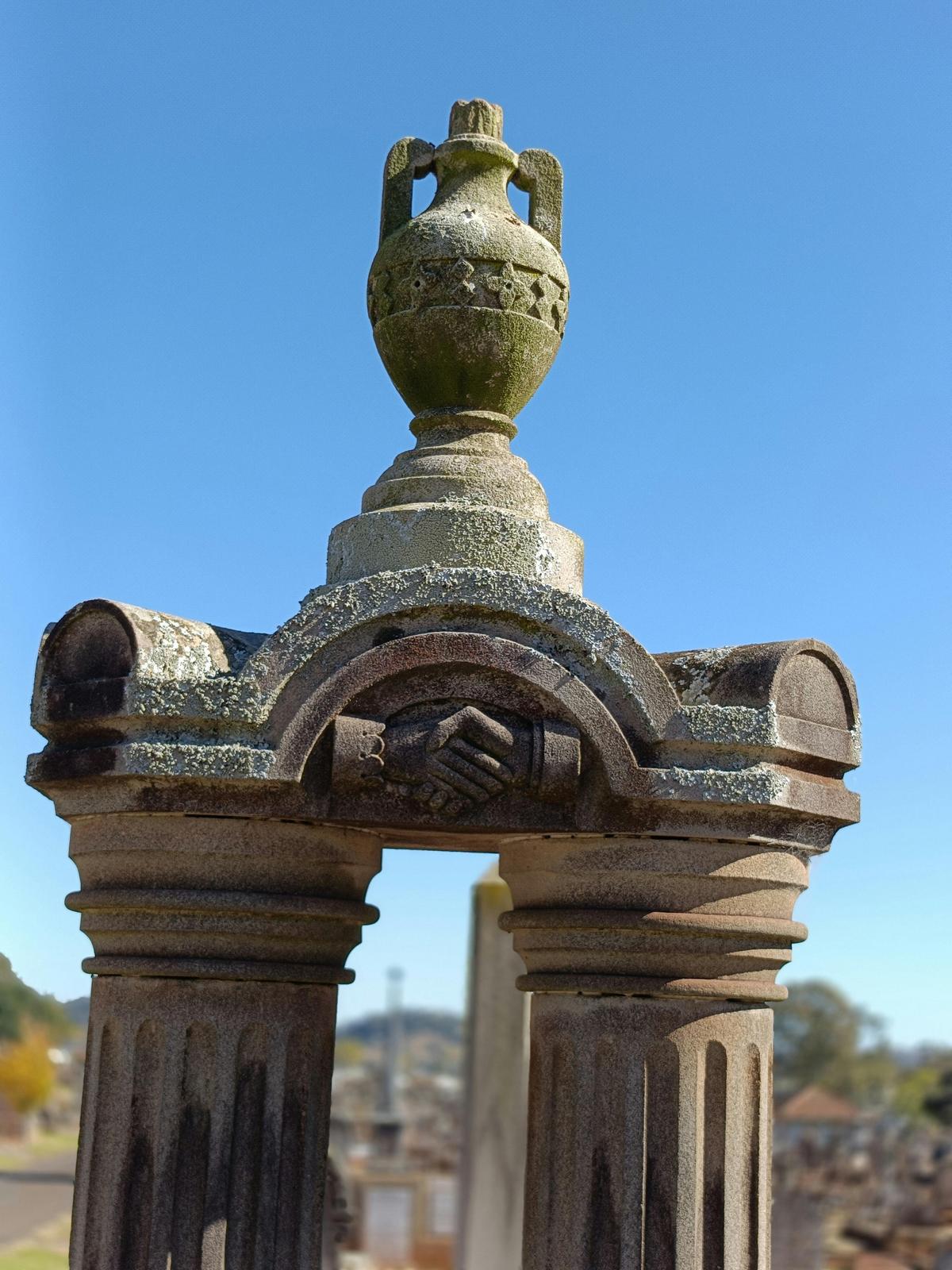 Cemetery monuments are adorned with symbolism. Clasped hands indicate marriage or a close bond.