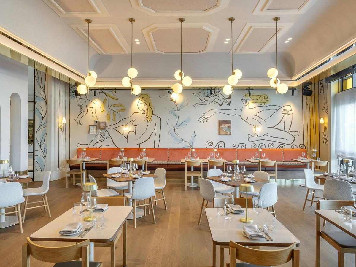 The dining room of Cucina Regina, with Italian murals on the walls