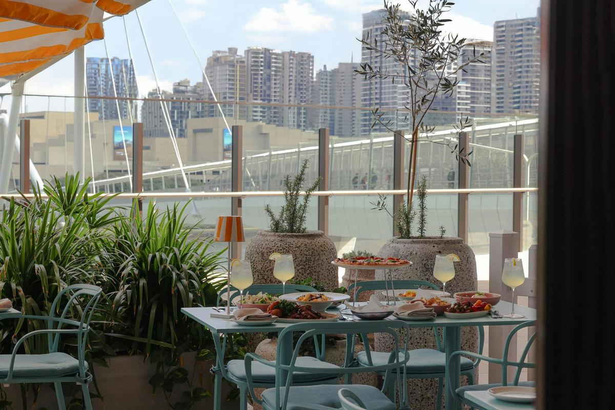 A table overlooking the river filled with Italian food
