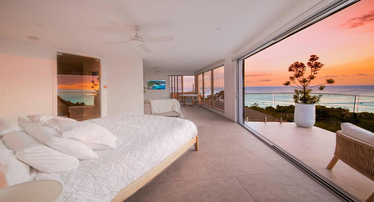 King bed with ocean view from Coolum Beach apartment