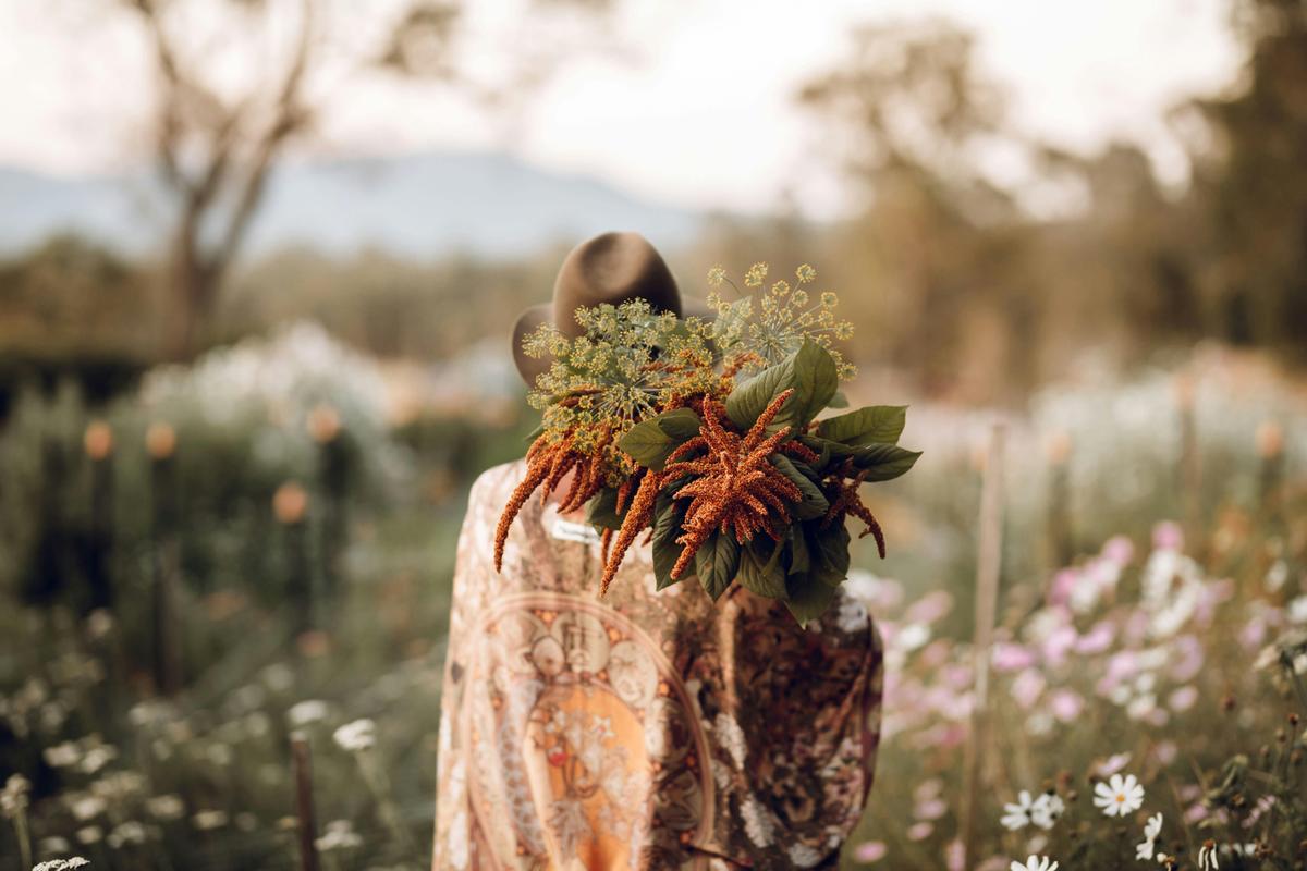Curlew Ridge Flower Field at sunset with owner Amanda holding flowers