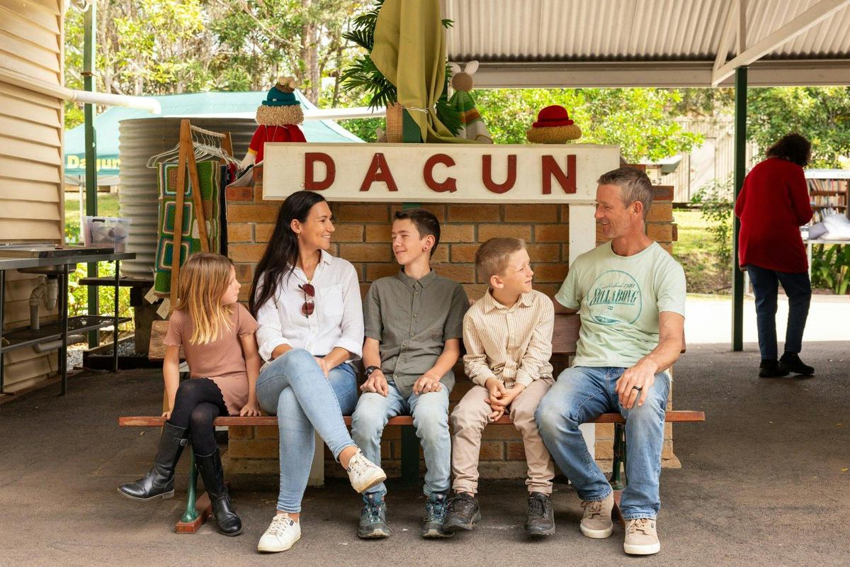 A family seating in front of the Dagun sign at the Dagun Station