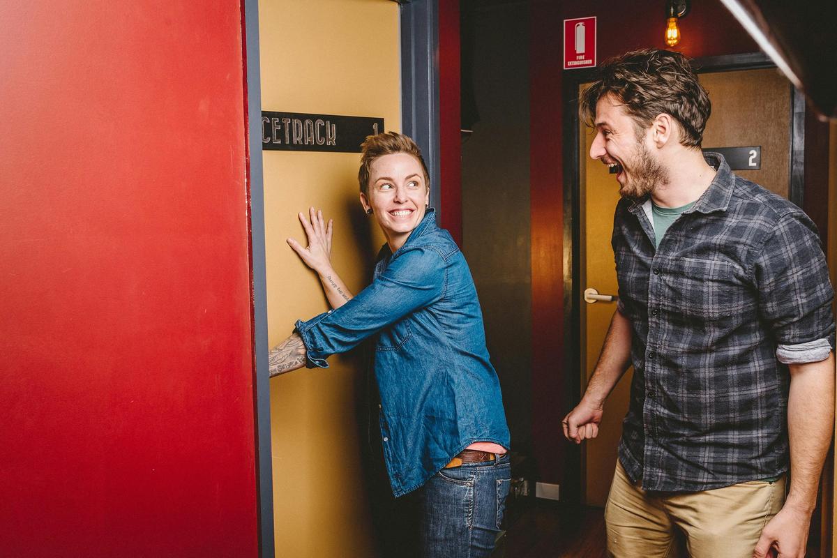 2 people expectantly opening the door and entering an escape room