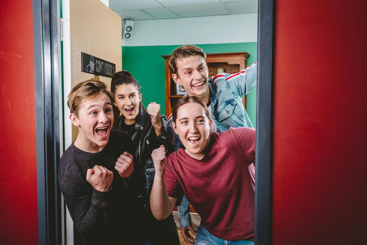 Group of 4 cheering as they break out of the escape room