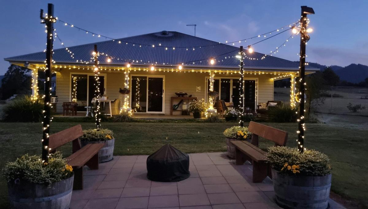 The cottage and firepit area at Fig Tree Farm is lit by fairy lights at night