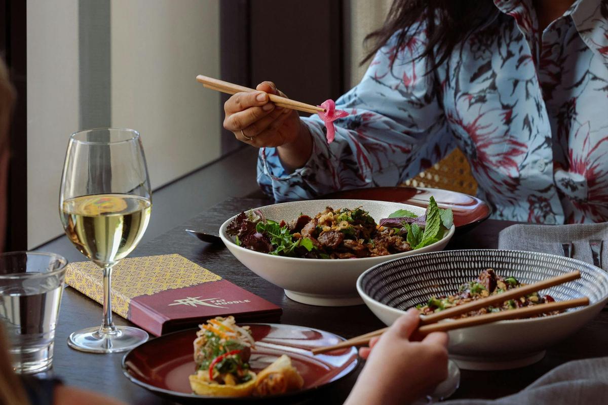 people eating noodle bowls at fat noodle