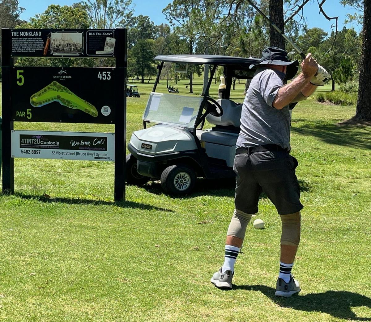 GGC member tees off at the 5th tee with historical gold mine sign in the background