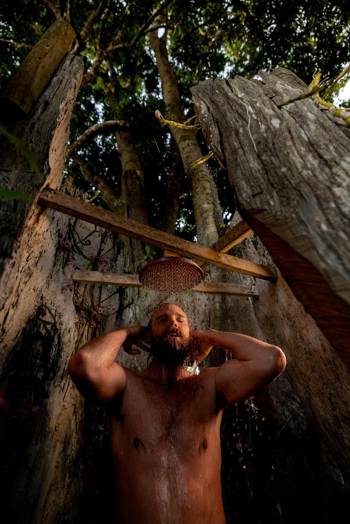 Outdoor tree shower surrounded by lush gardens