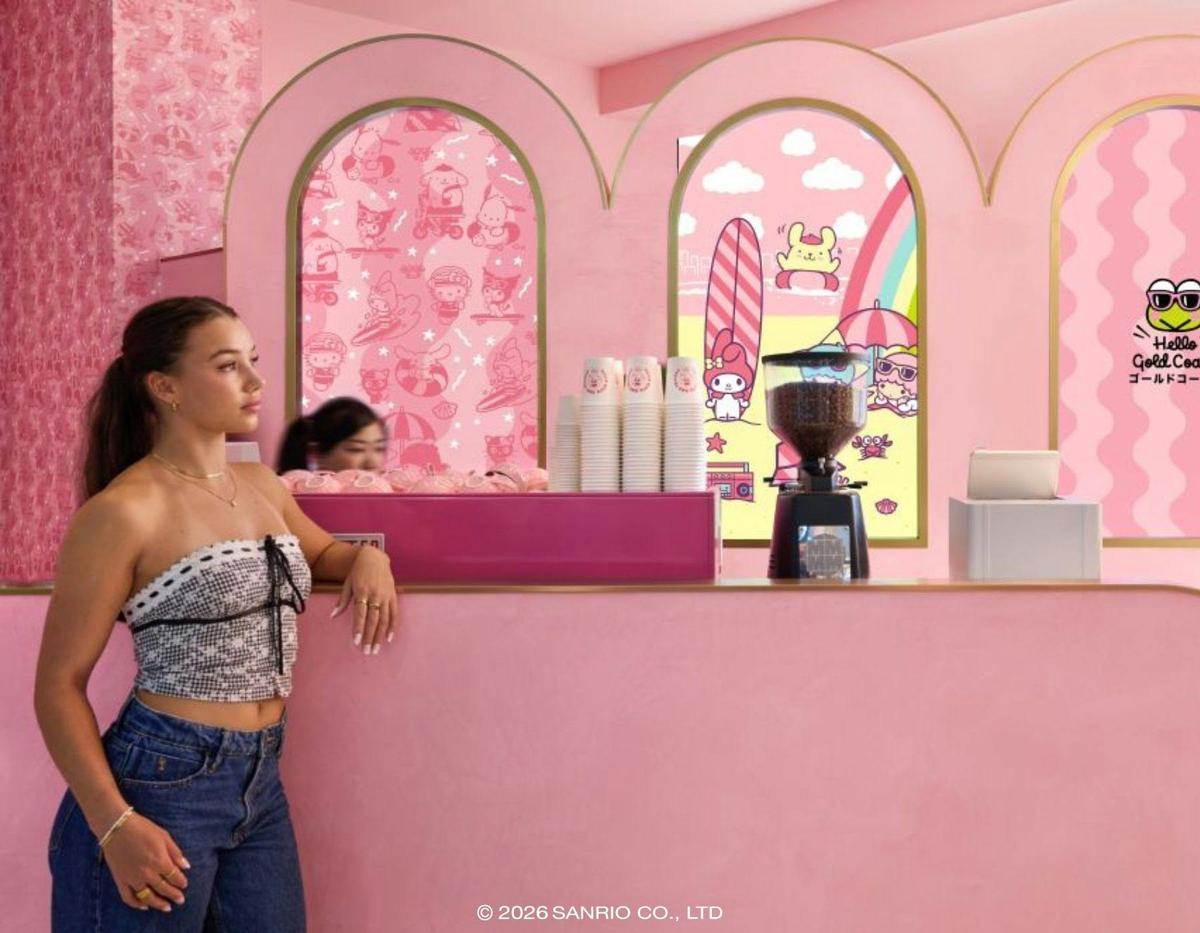 A cafe area with pink seating and a wall featuring colorful Sanrio character art.