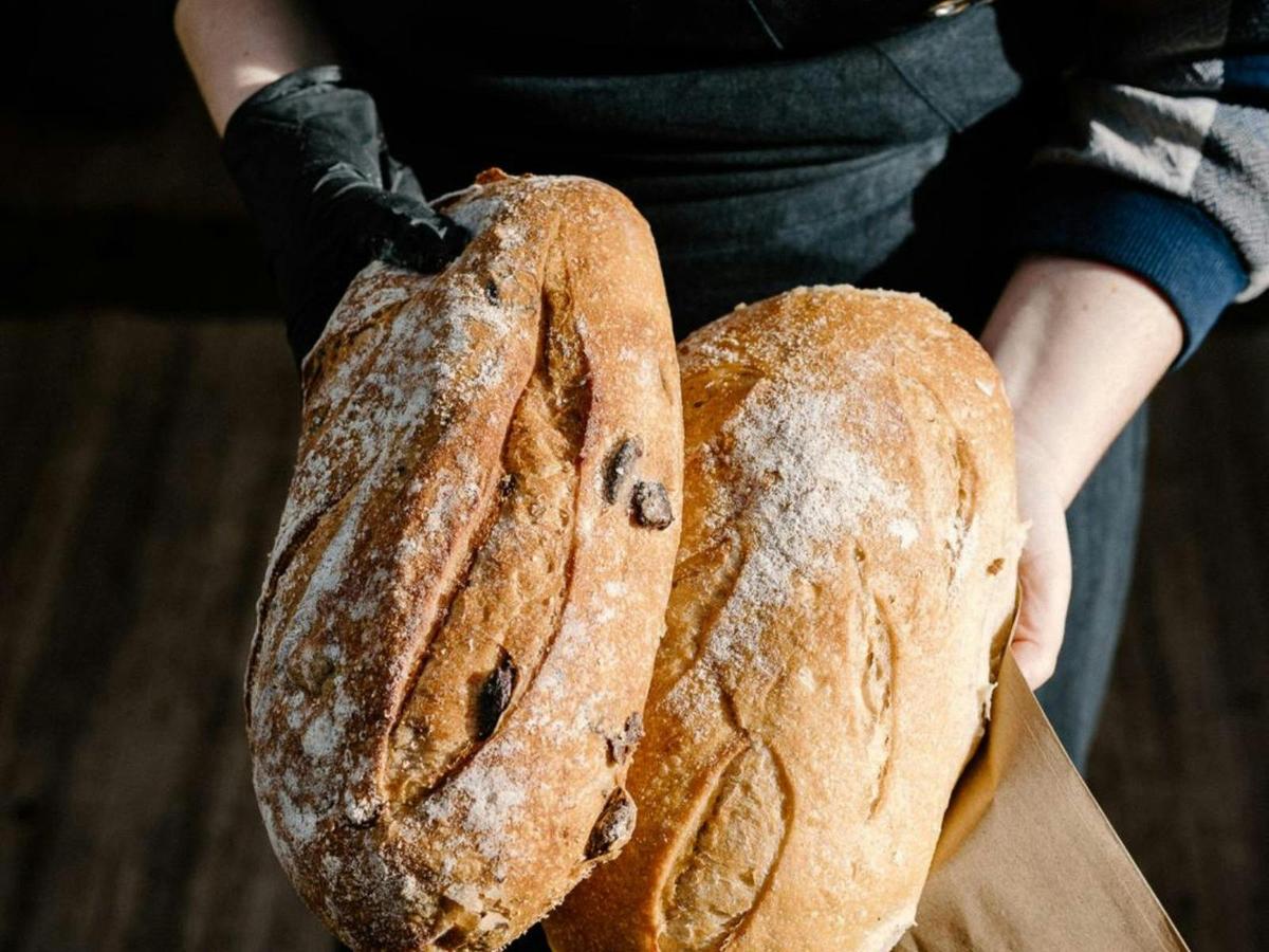 Fresh sourdough bread held by the baker at JPFM