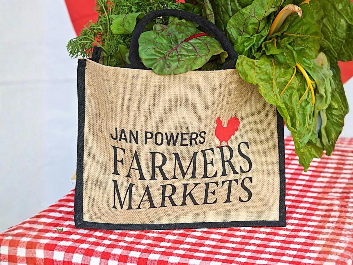 A JPFM hessian market bag overflowing with fresh produce