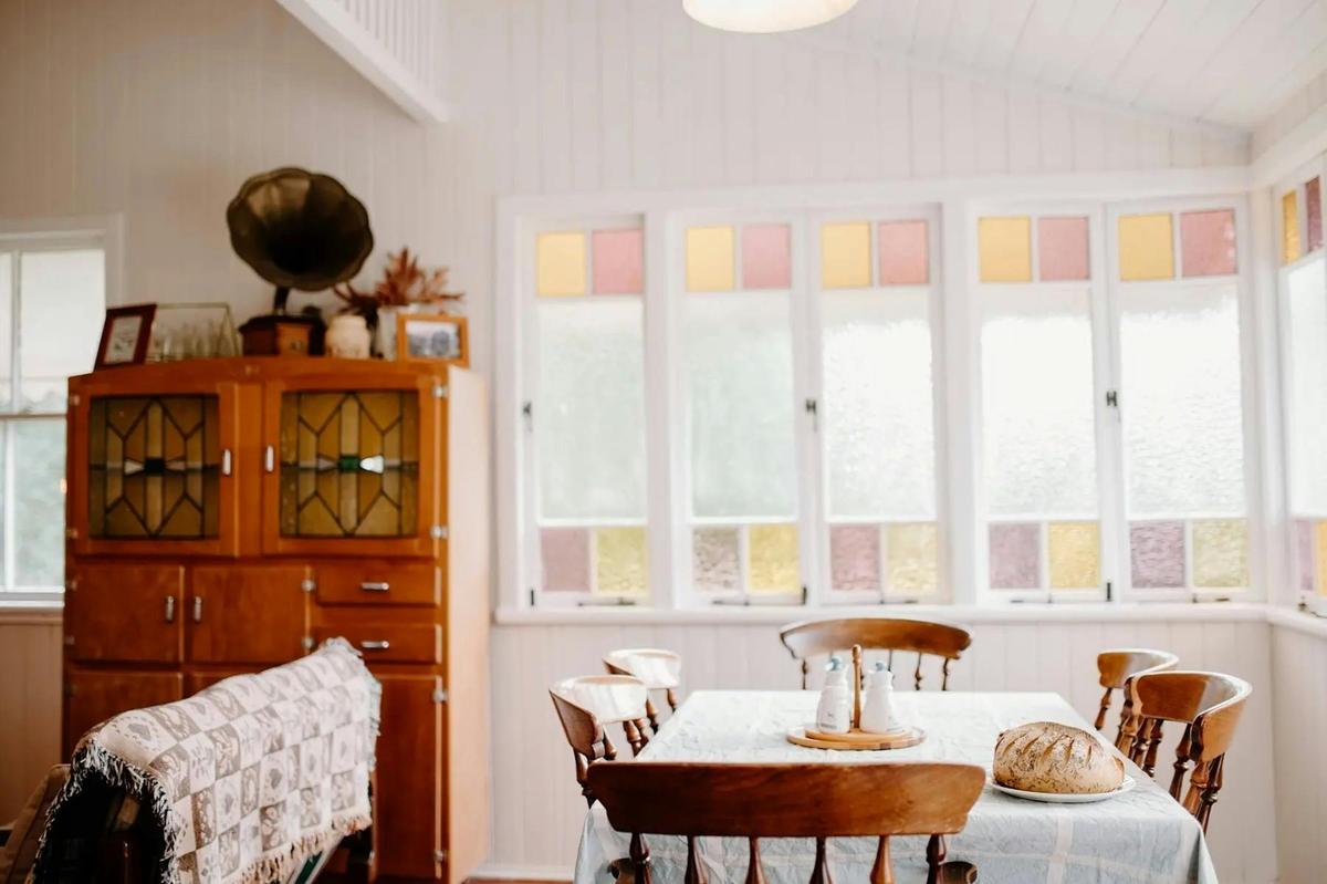 The light-filled sunroom, where coloured-glass windows frame long, relaxed country meals.