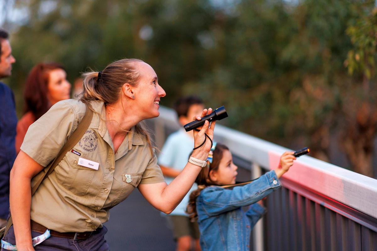 Tour guide and young girl spotlighting wildlife