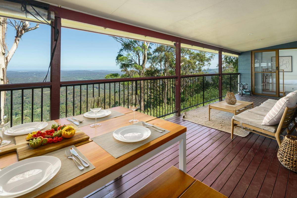 Enjoy alfresco dining on the balcony's outdoor table, offering stunning views of both the hinterland