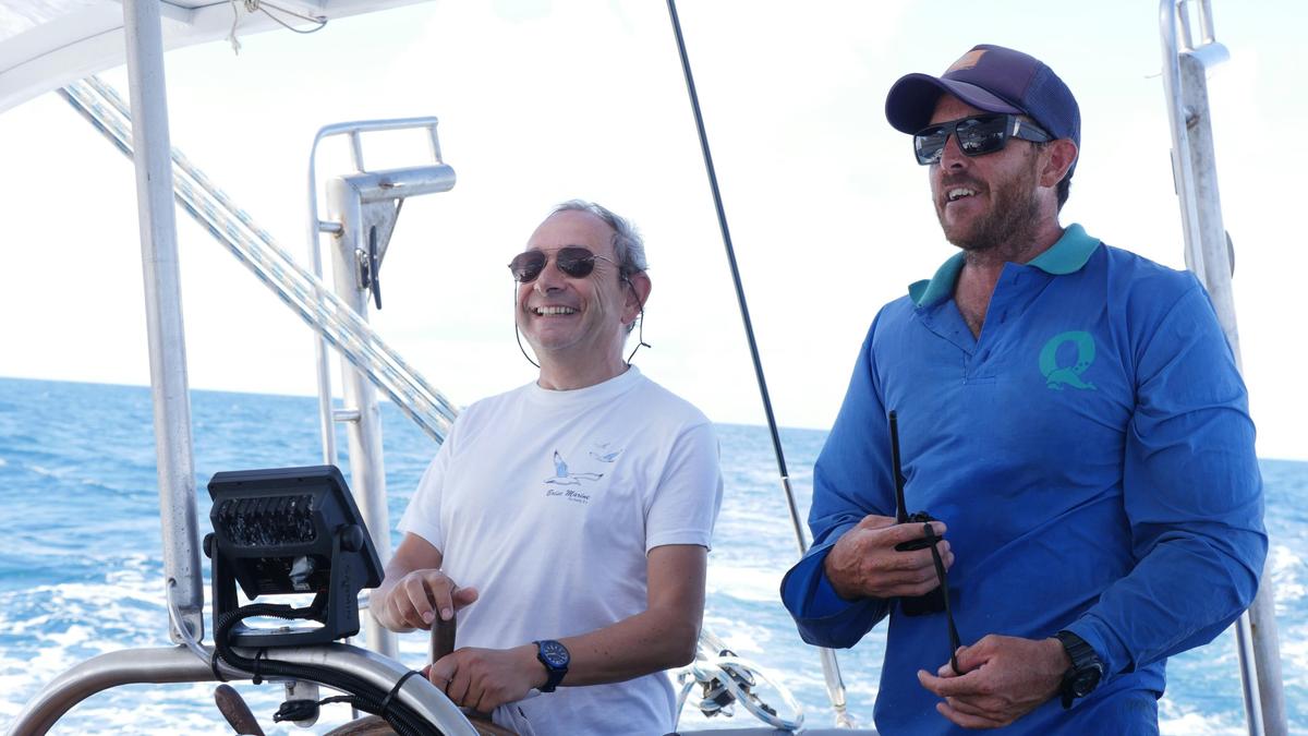 Guest having a go at the helm with skipper of Ocean Free