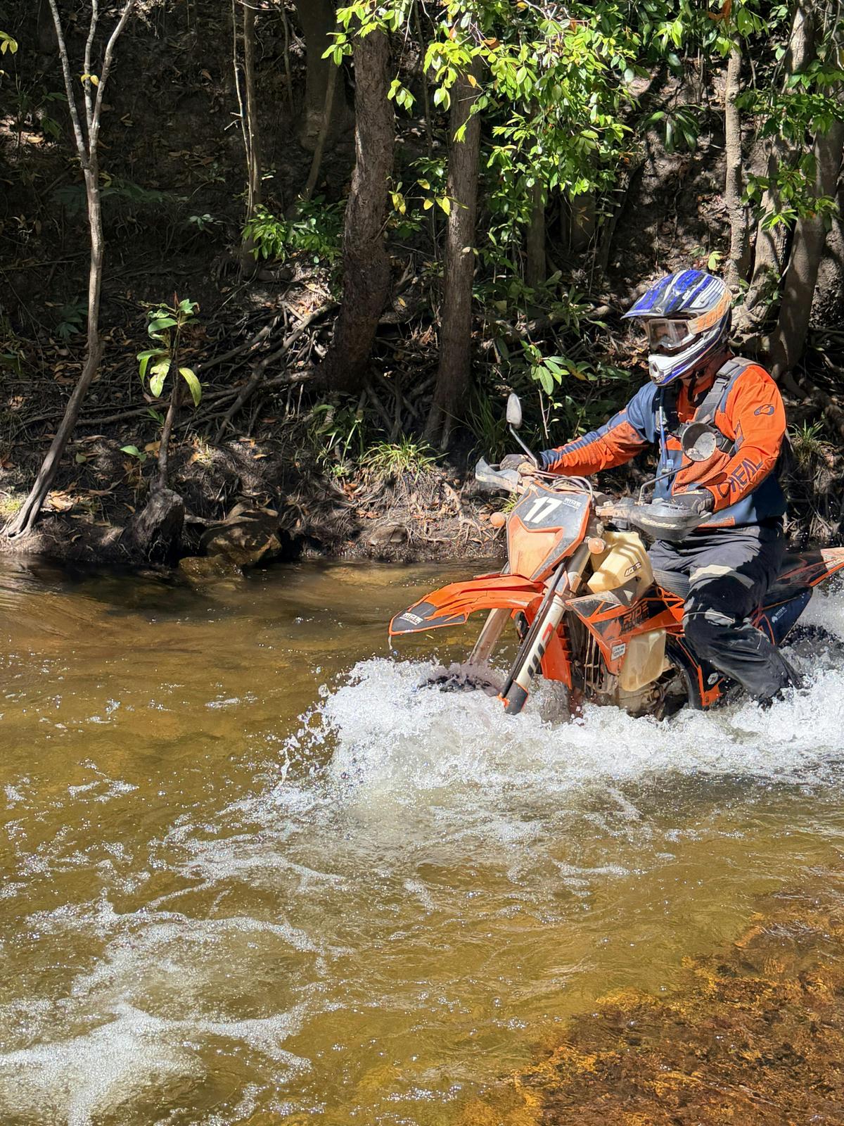 KTM riding through a creek crossing