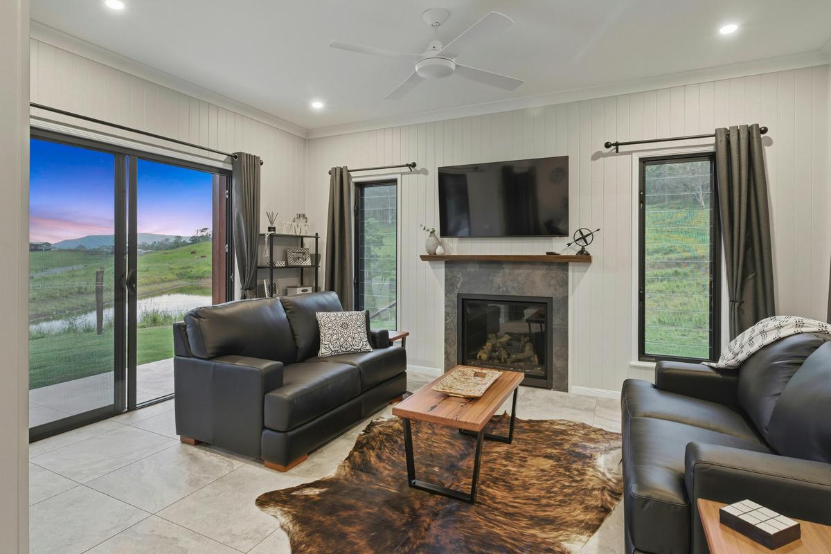 Conondale Lodge living area with fireplace and views across the dam