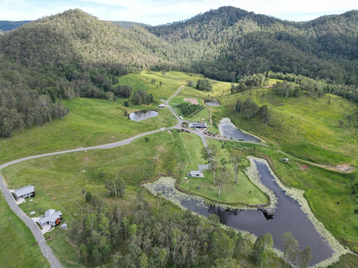 Aerial view of eco-lodges, dams, and rolling green hills at Seven Hills Estate
