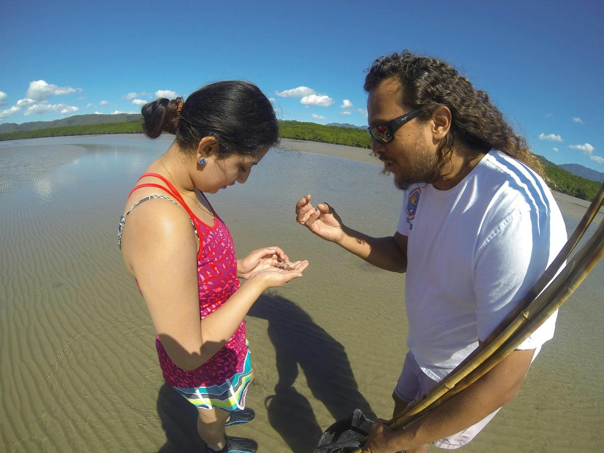 Indigenous guide teaching students about traditional hunting practices