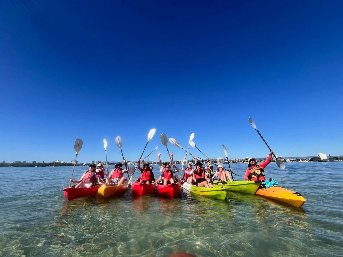 Guests celebrating their kayaking adventure in the shallow waters of the Gold Coast Broadwater with