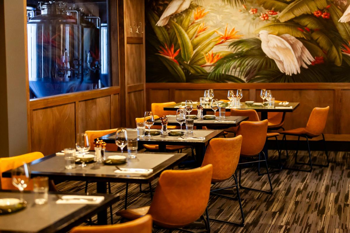 A dining room with brown leather chairs and grey tables