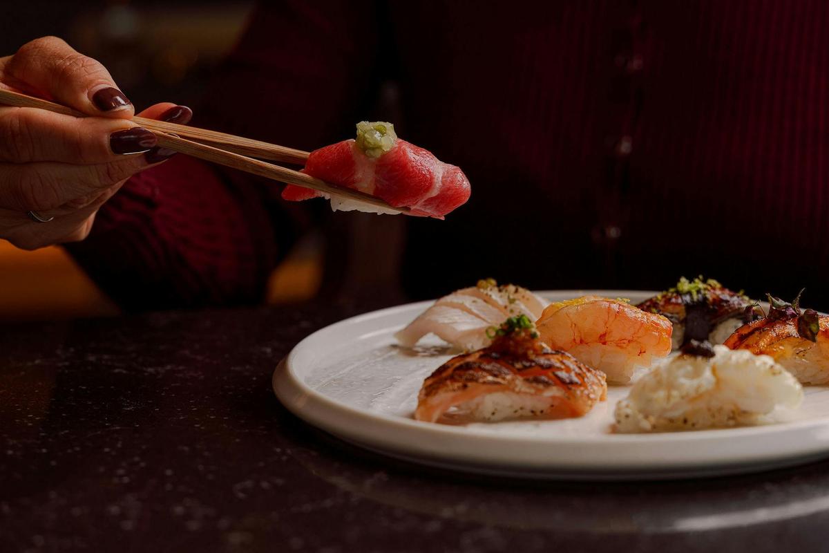 Chopsticks picking up a piece of sushi