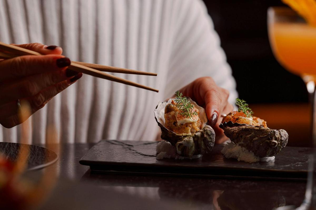 chopsticks picking up a fried oyster