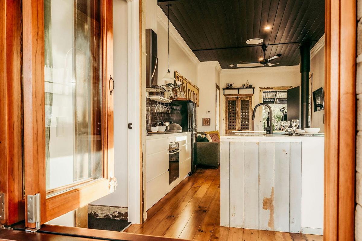 The timber bi-fold window opens up to connect the front porch and living areas.