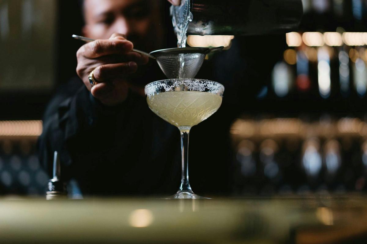 Bar tender pouring cocktail