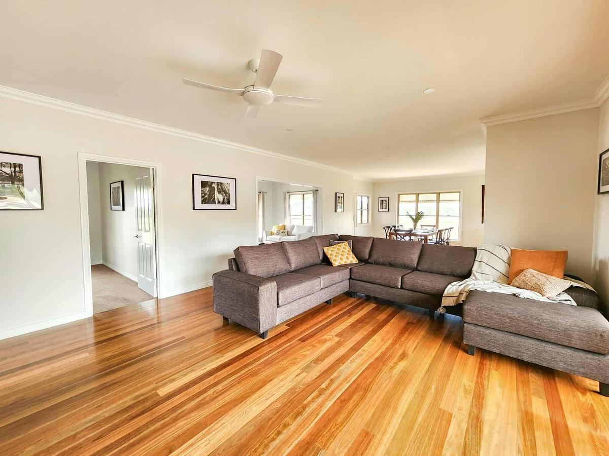 Spacious open living room with wood combustion heater and access to verandah