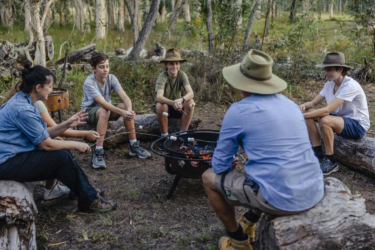 Family spending quality time together around the campfire, roasting marshmallows at Traveller's Rest