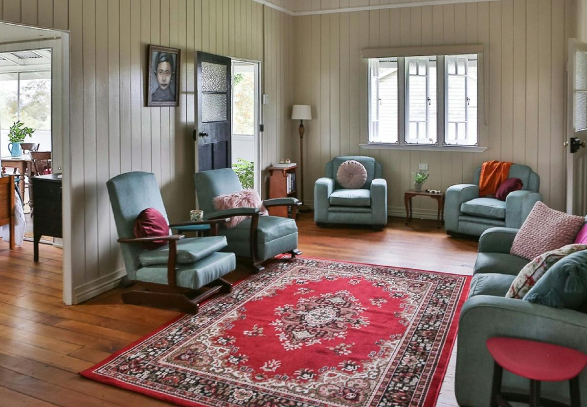 Spacious loungeroom with comfy chairs and a pot belly stove
