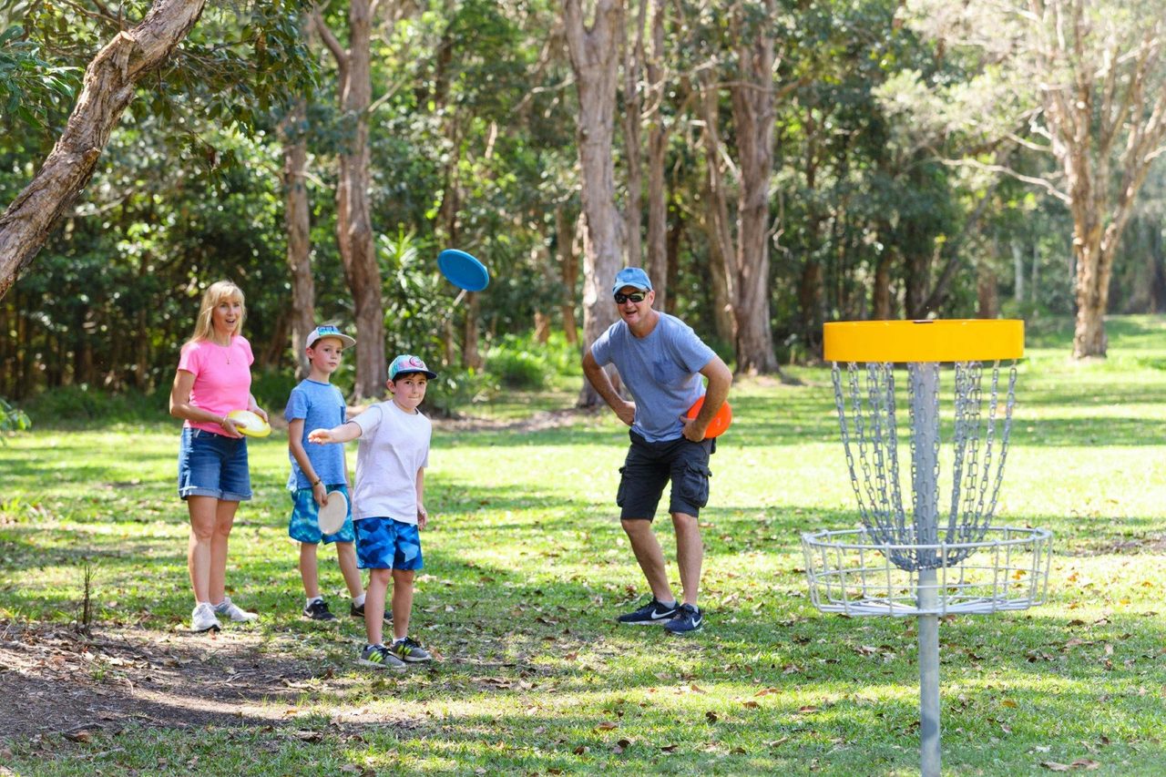 Family watching child play Disc Golf