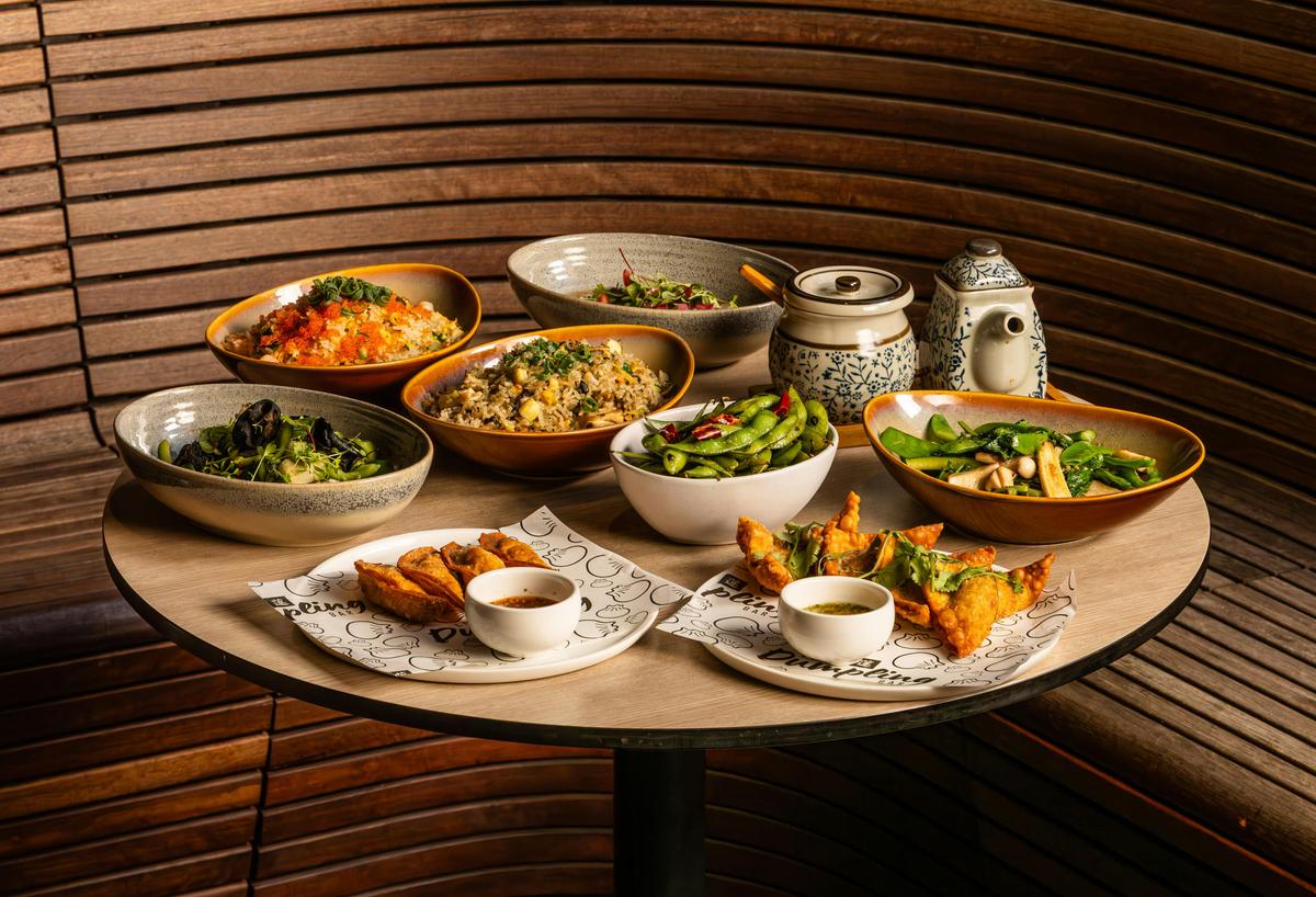 A selection of contemporary Chinese shared dishes, featuring fried rice and wok-fried vegetables