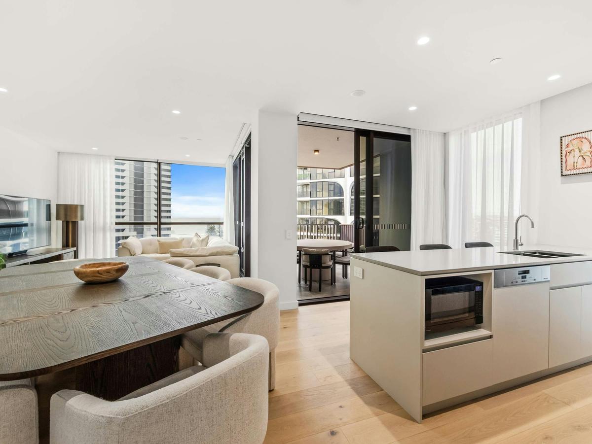 The living, dining and kitchen open together, with the ocean at the end of the room.