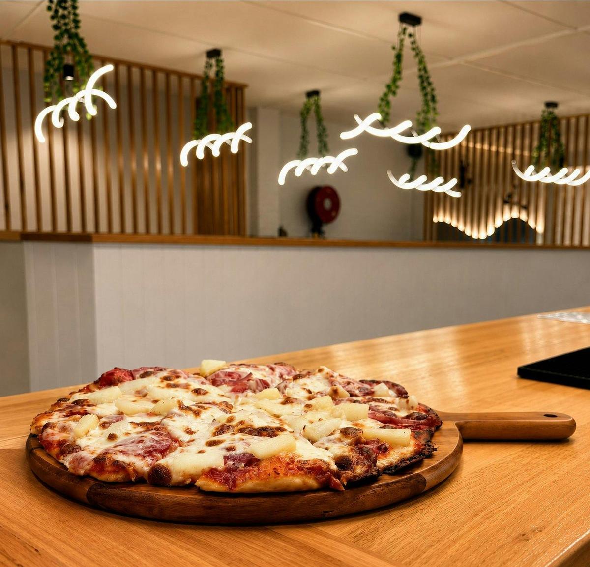 Freshly made Hawaiian pizza topped with ham, pineapple and mozzarella.