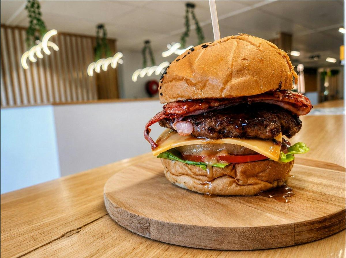 Our Tropical Burger stacked with bacon, pineapple, cheese, salad and house burger sauce.