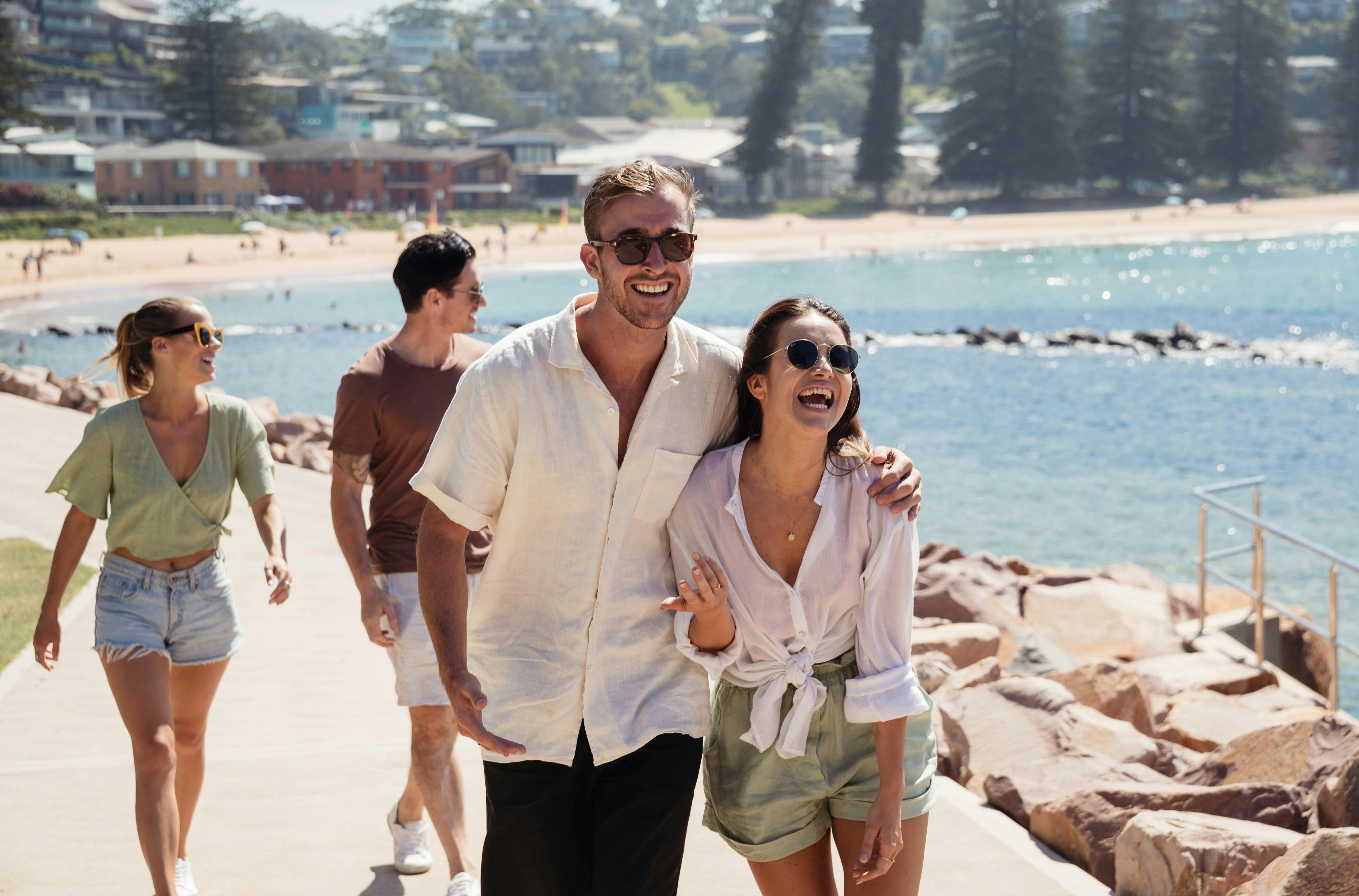 Couples walking along pathway near the beach