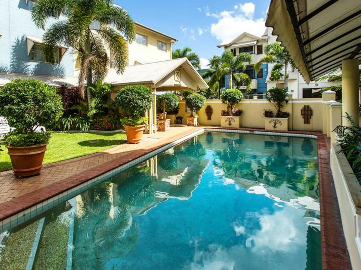 Outdoor pool surrounded by tropical greenery at K2 Queen's Court