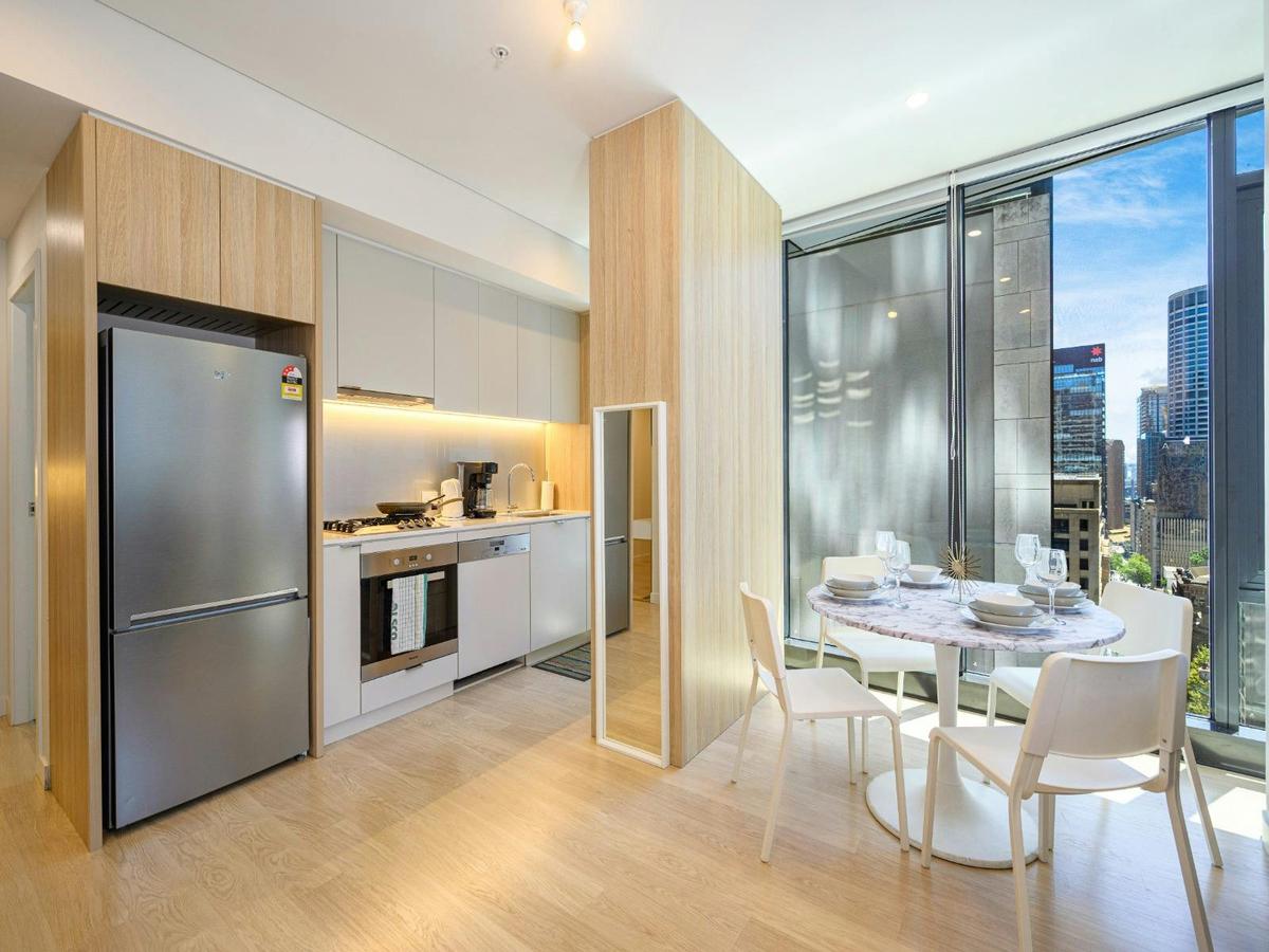 Modern kitchen with fridge, oven, cooktop, and cabinetry.