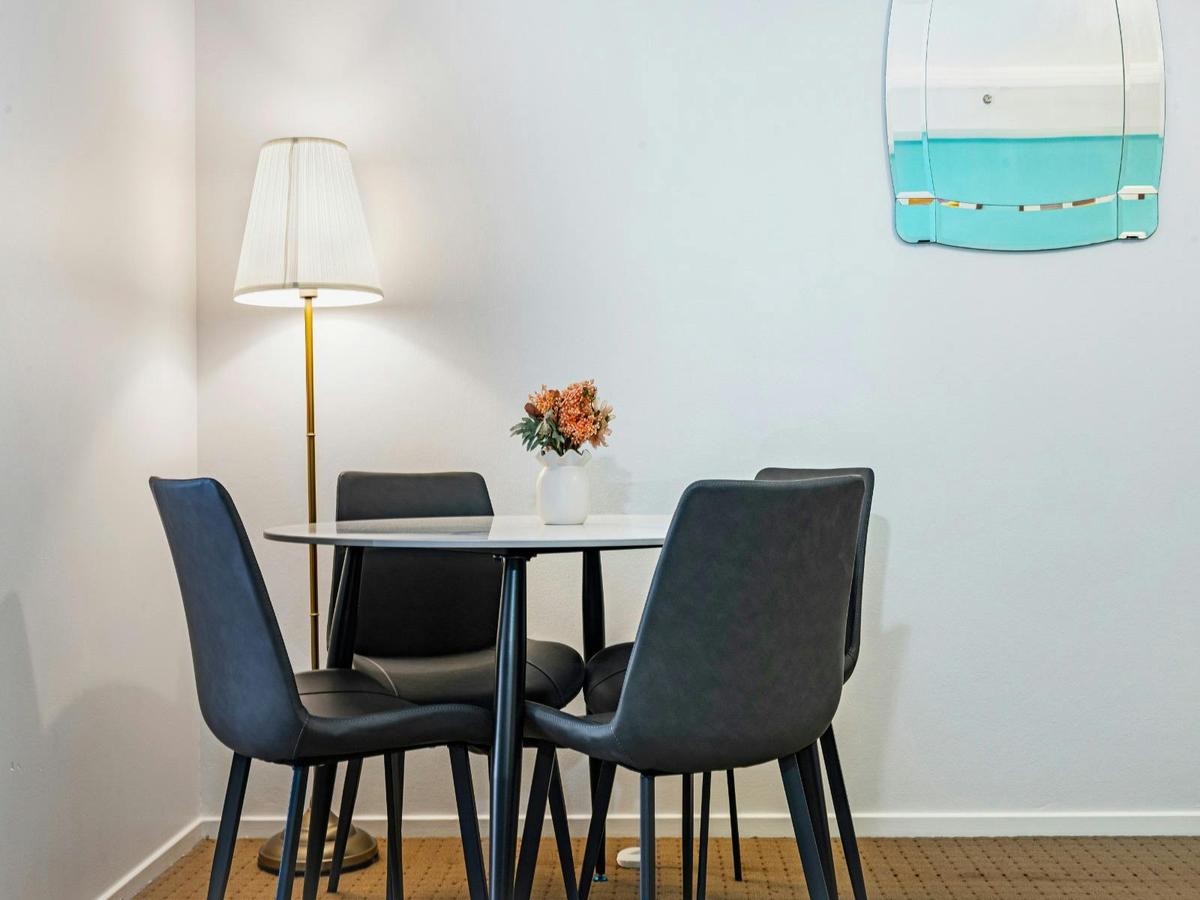 Small dining setting with round table and chairs, complemented by soft lighting.