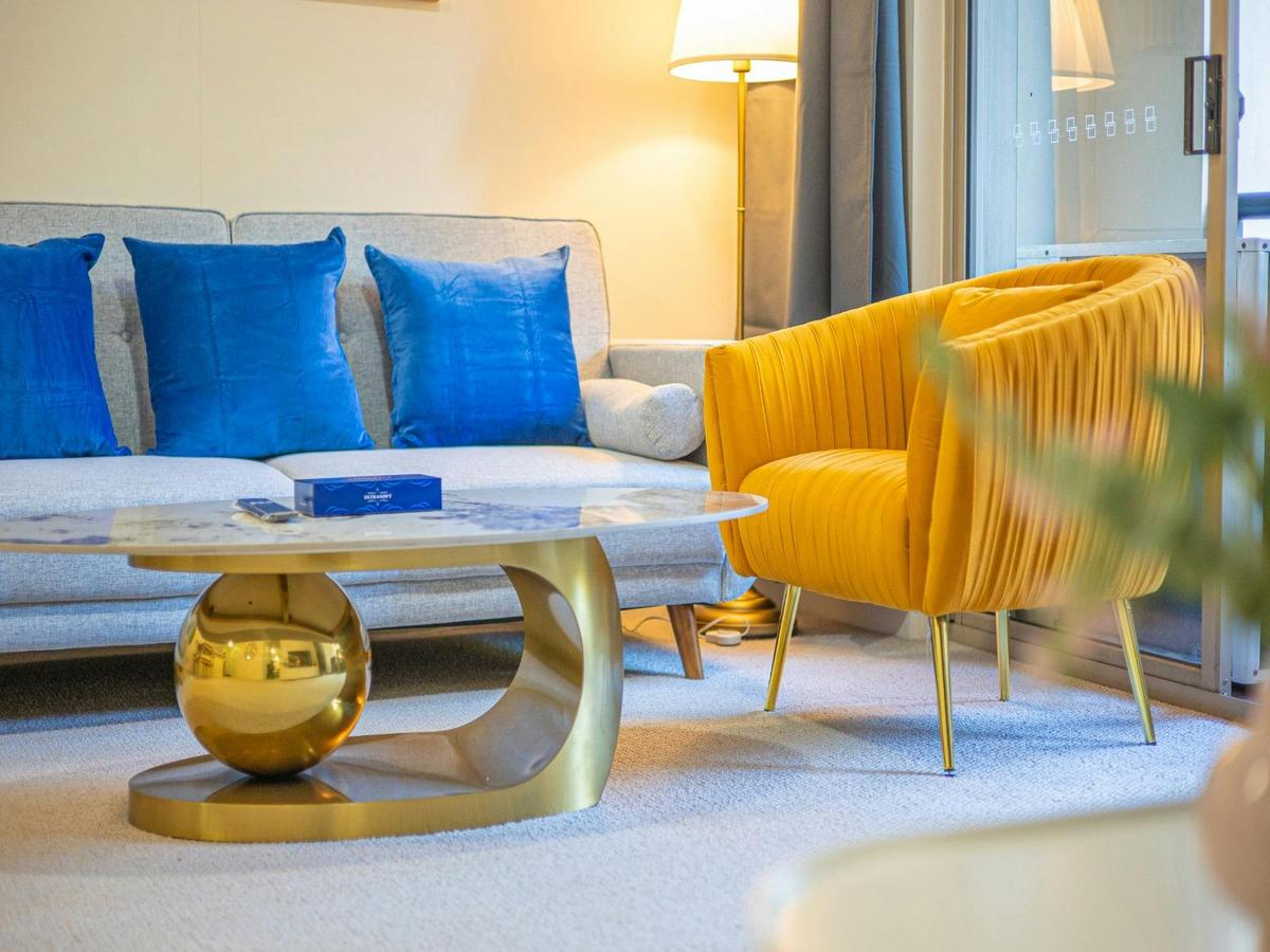Living room with comfortable seating and a sofa bed, coffee table, and stylish accent chairs.