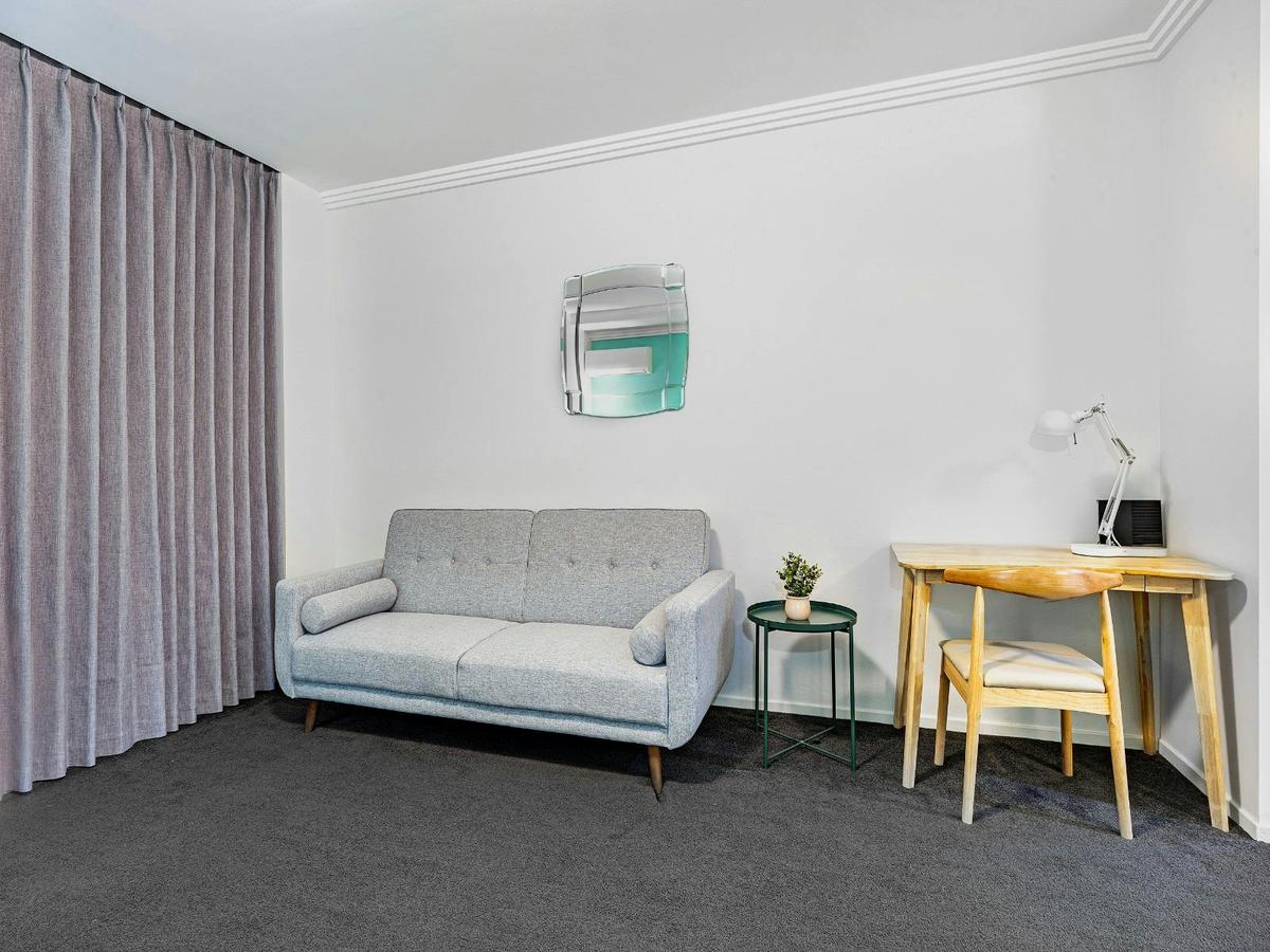 Cozy living area with a sofa bed, side table, and neutral décor.